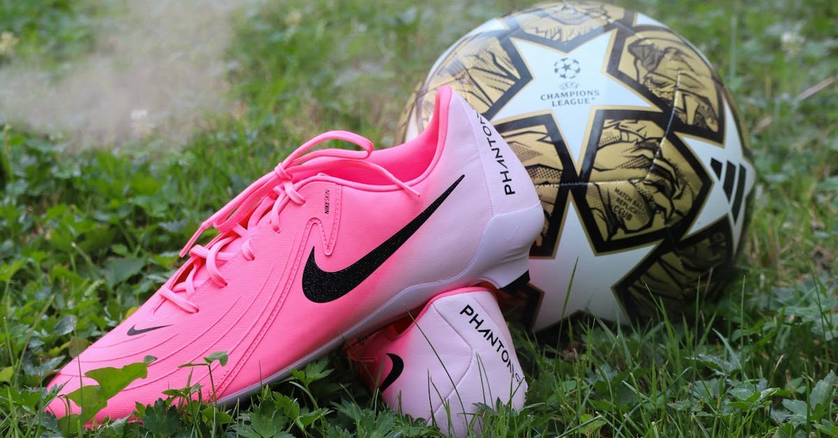 Bright pink soccer cleats and ball on lush grass; perfect for sports themes.